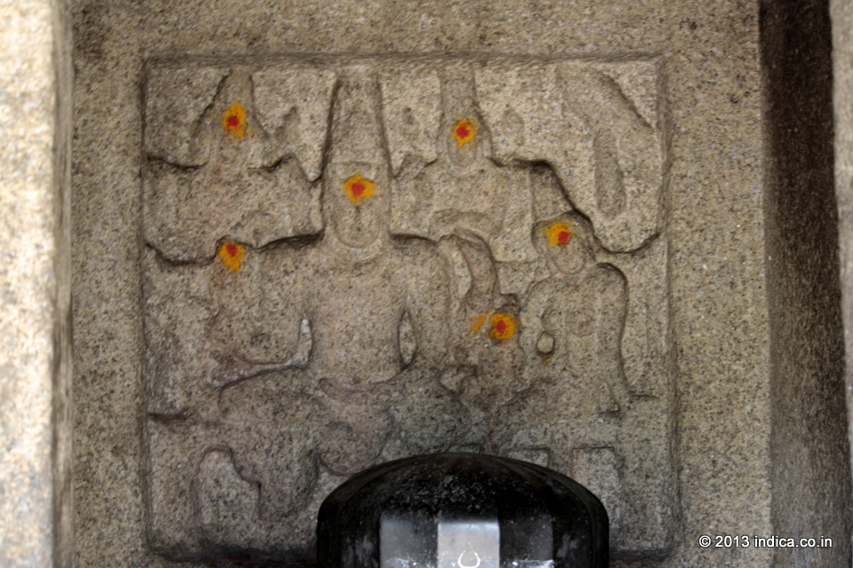 Panel inside the Atiranachanda Cave in Mahabalipuram. Seat beside Lord Shiva is Parvathi , the consort of Shiva. Seated on the lap of Parvathi is their son, Skanda . You can also see the tip of the prismatic  linga in the foreground, probably a later addition during the early 19th century. 