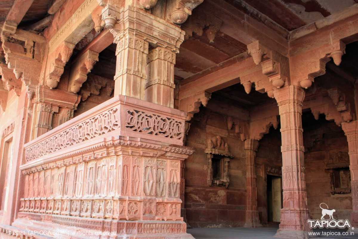 Red sandstone carved pillar inside Jodha Bai Palace