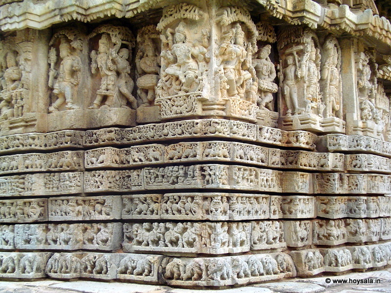 The 6 layered frieze over which the boldly executed sculptures are installed around the outer walls. All are done in soapstone.  The bottom represents a elephants is various postures, all unique, above which is a series of horses, the next band represents lions. Above this is a sequence of mythical themes carved in sequence (like in a comics strips). The top two bands are of peacock and a mythological creature.  