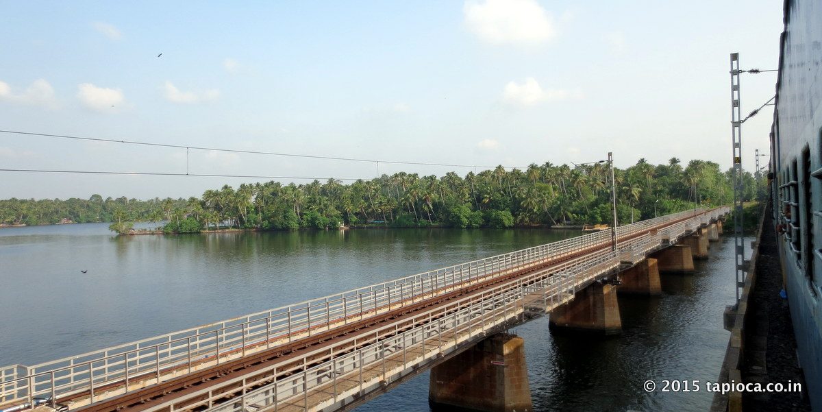 Railway line crosses the palm fringed Ashtamudi backwaters near Kollam (Quilon)